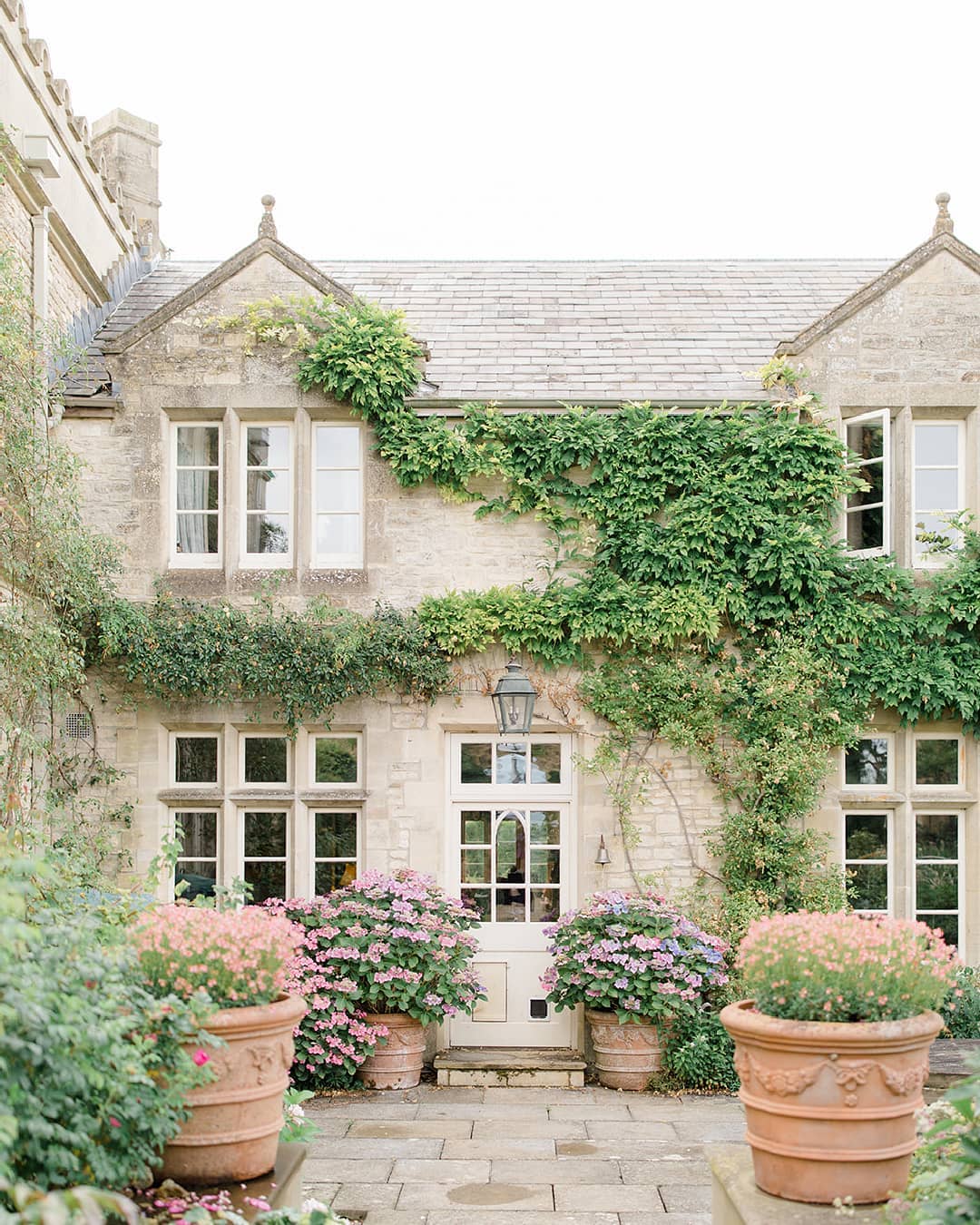 English garden cottage wedding venue with climbing ivy and terra cotta urns