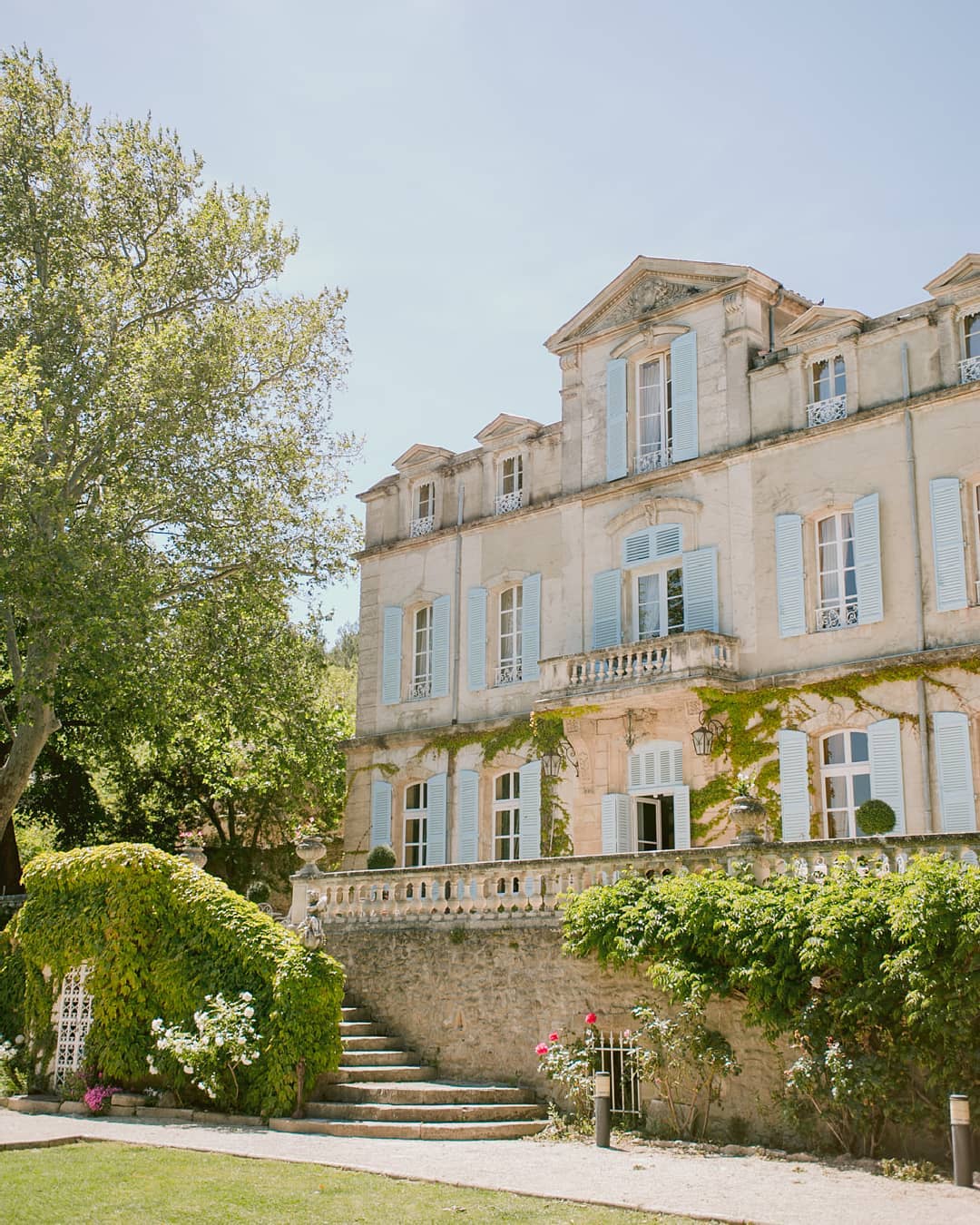 French chateau wedding venue with pale blue shutters and climbing ivy
