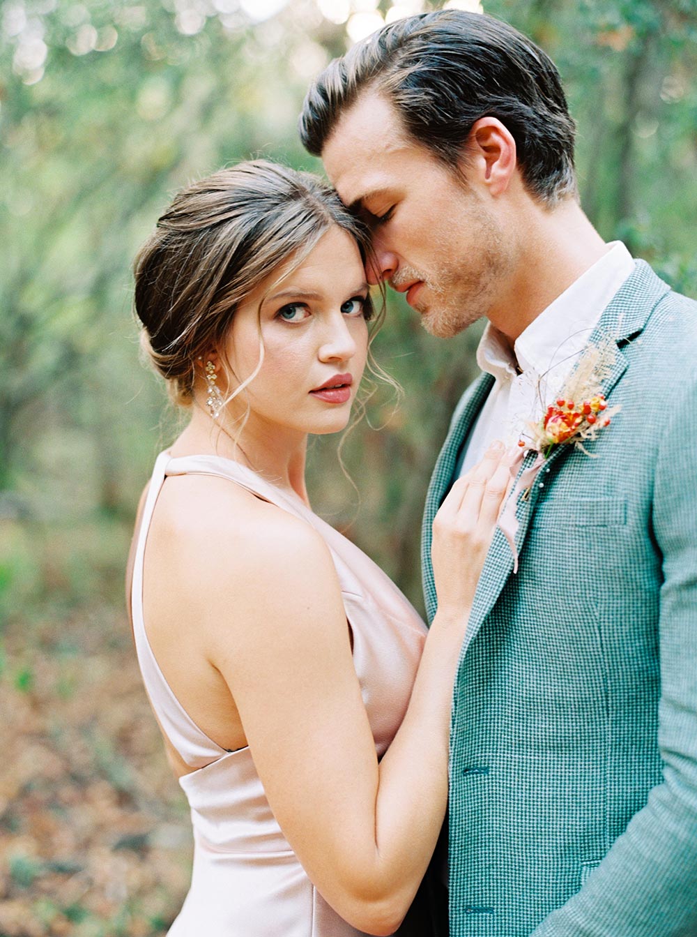 autumn wedding ceremony with a groom in sage green suit and a bride in apricot silk gown and romantic, wispy updo