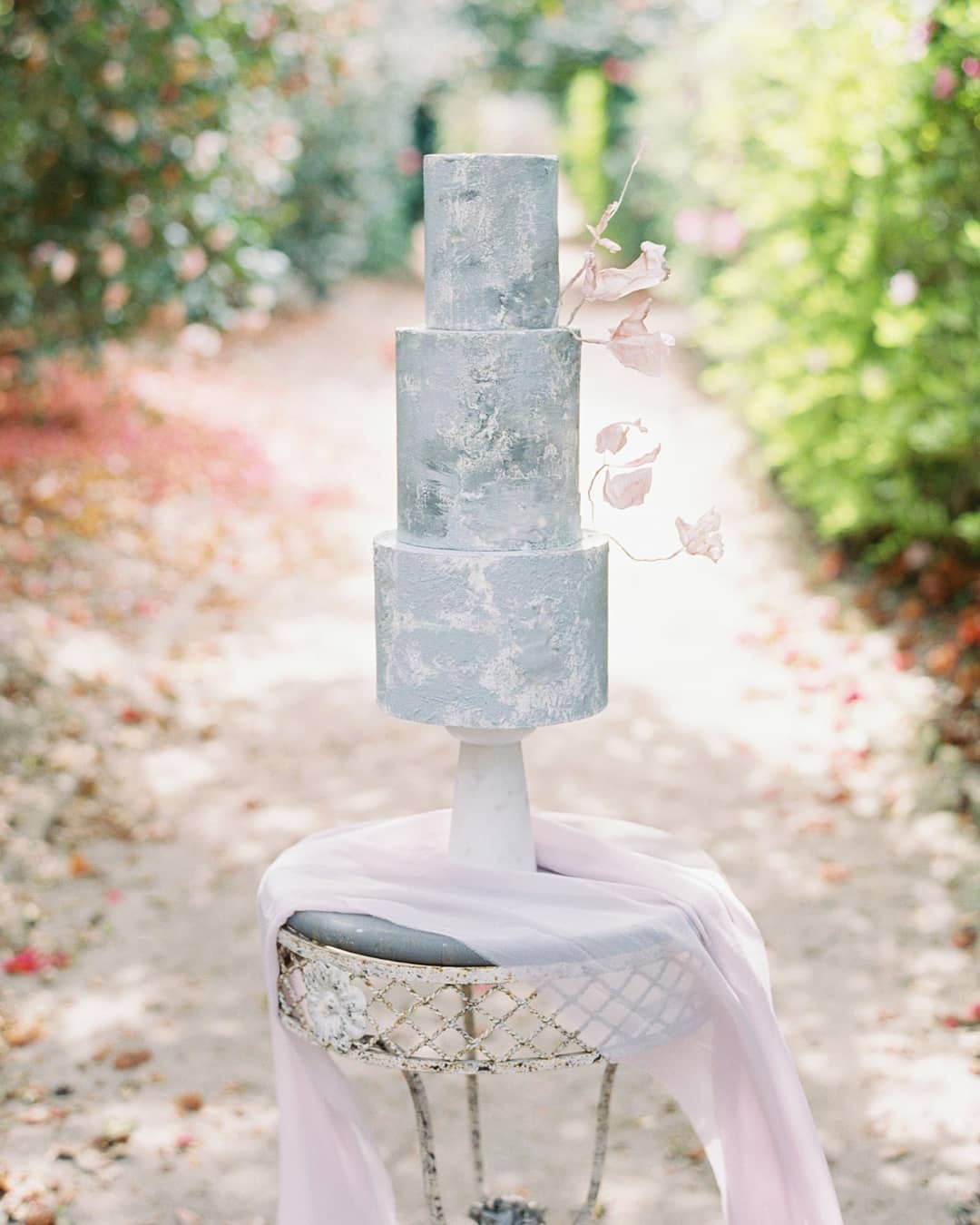 concrete texture wedding cake with a lilac silk runner