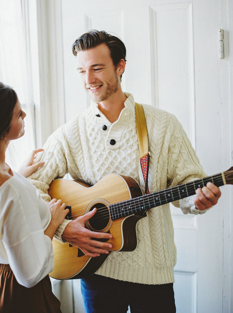 cream fisherman sweater from LL Bean on a handsome man playing the guitar to his girlfriend