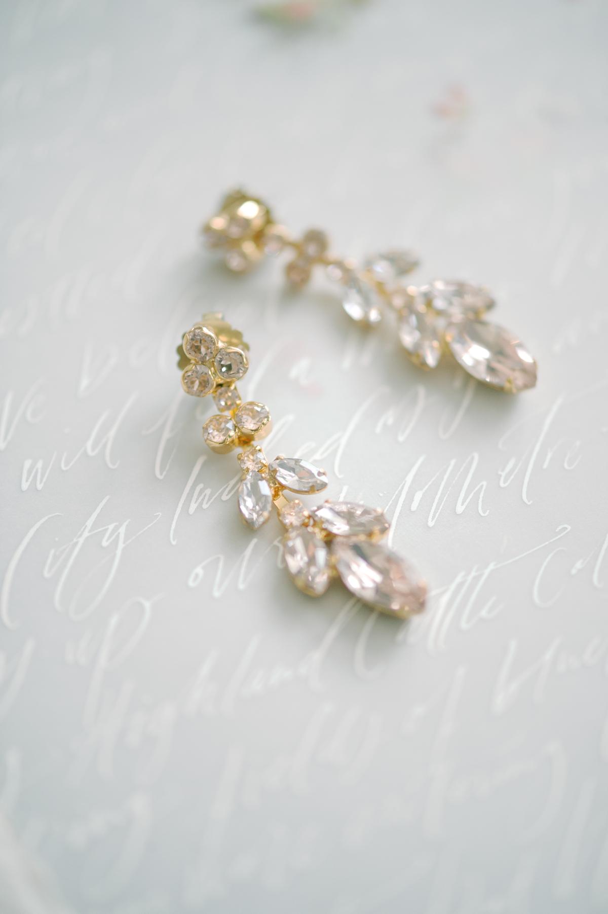 crystal petal drip earrings from BHLDN with calligraphed vows on vellum paper; photography by Julie Livingston at an English country estate Hedsor House with planning and design by Willow and Oak Events