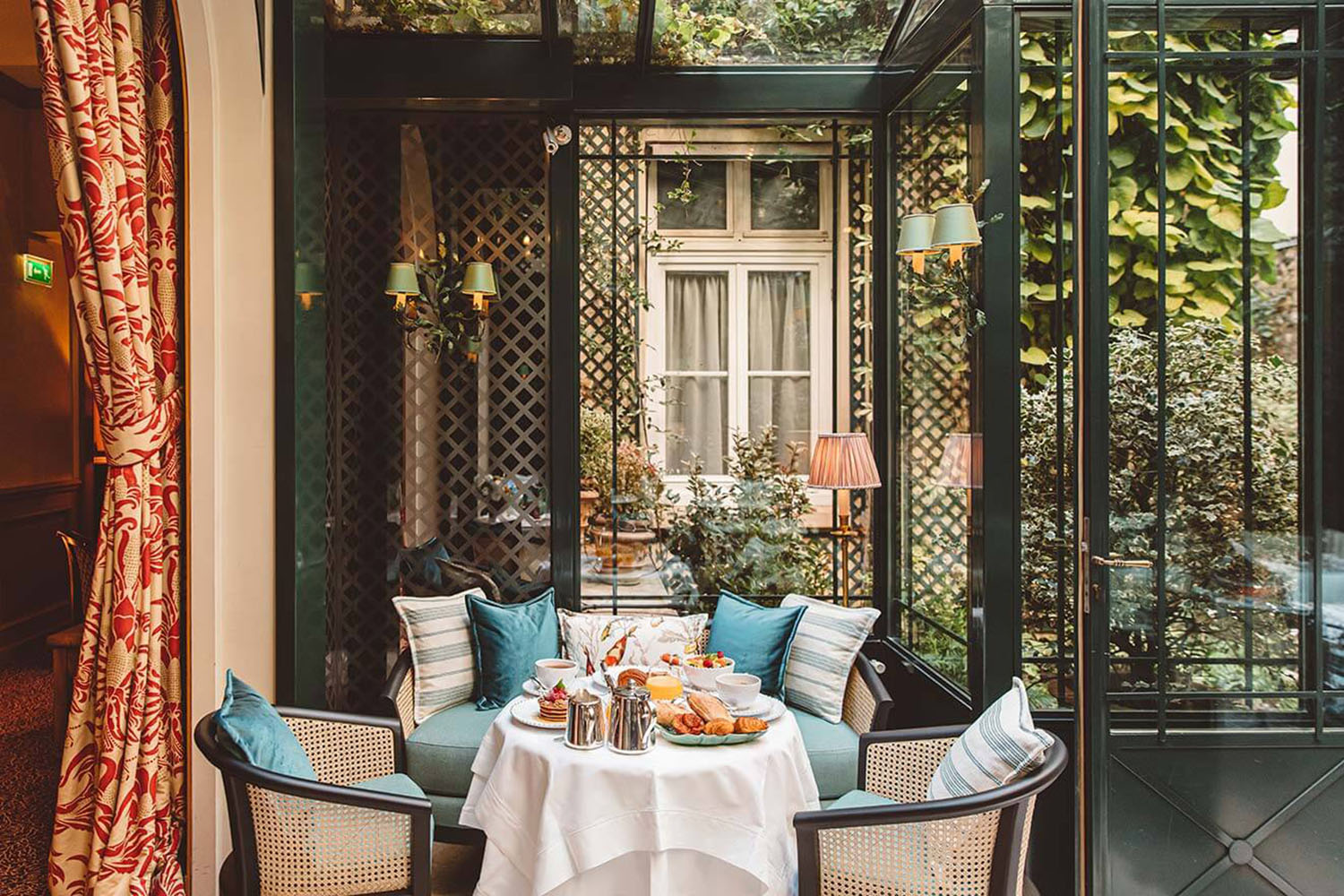 A winter garden table at the restaurant of Hôtel de l'Abbaye with mixed blue pillows in silk and velvet fabric