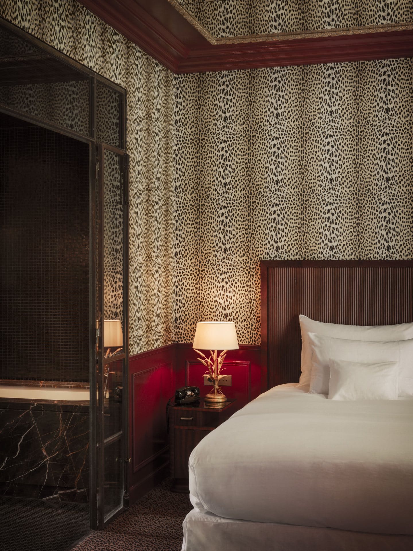 A leopard print wallpaper and red wainscoting for one of the guestrooms at Hôtel Particulier Montmartre