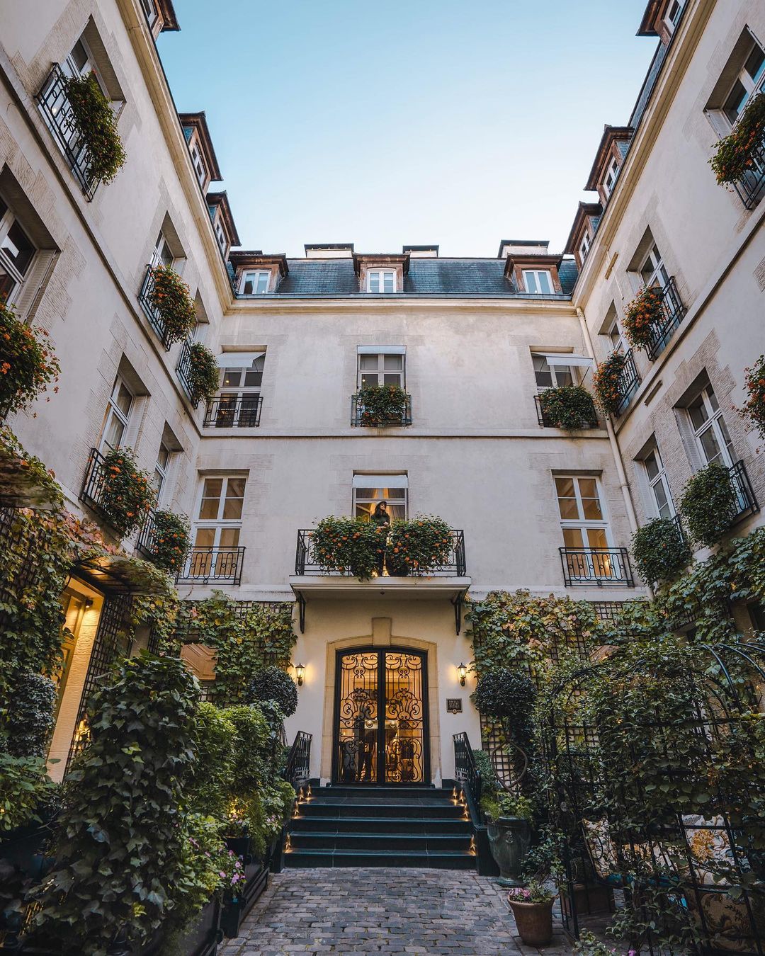 The ivy-covered courtyard entrance of Relais Christine in Paris